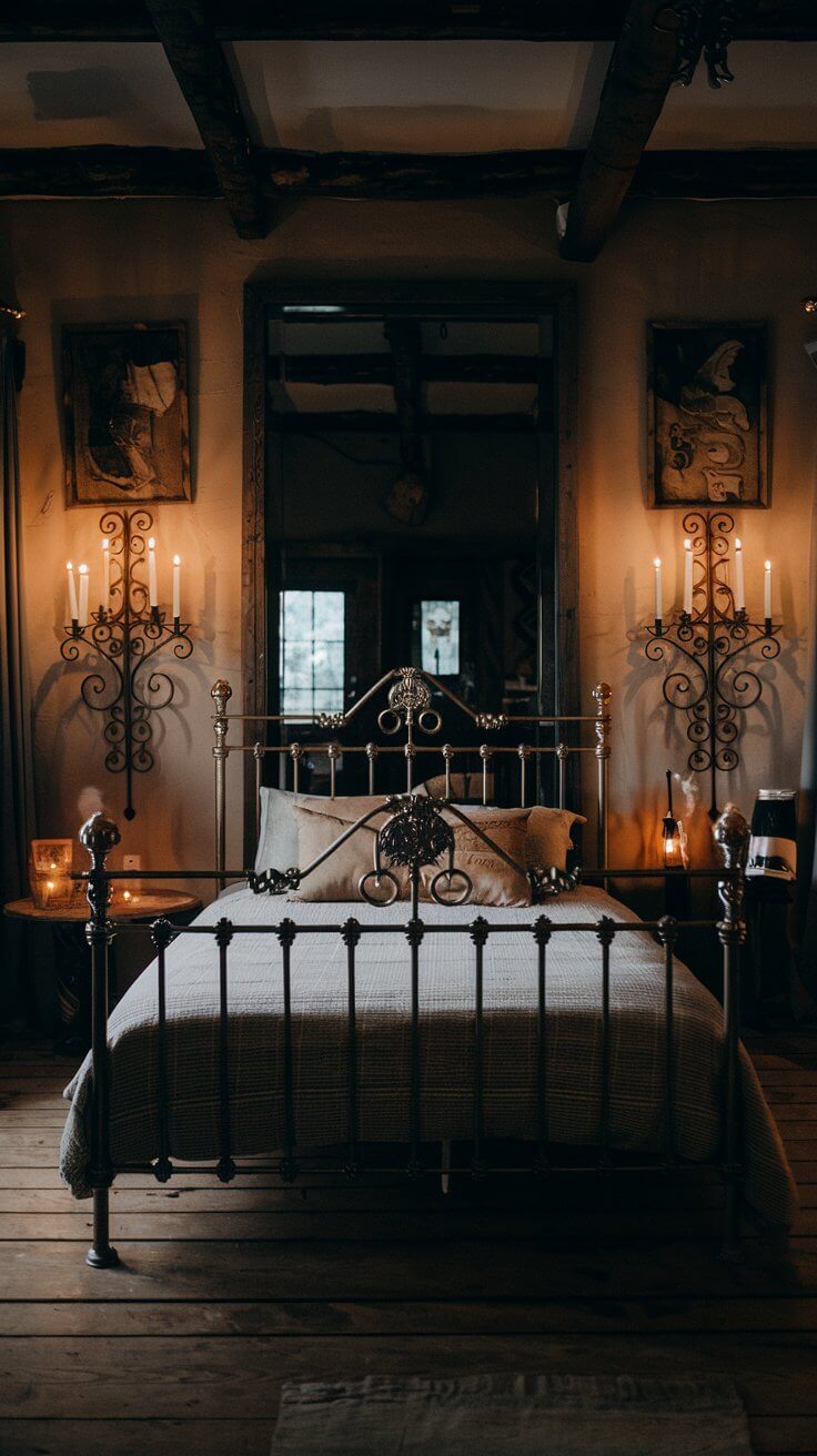 A dimly lit bedroom wall featuring two ornate wrought iron candle sconces with flickering pillar candles, casting warm shadows.